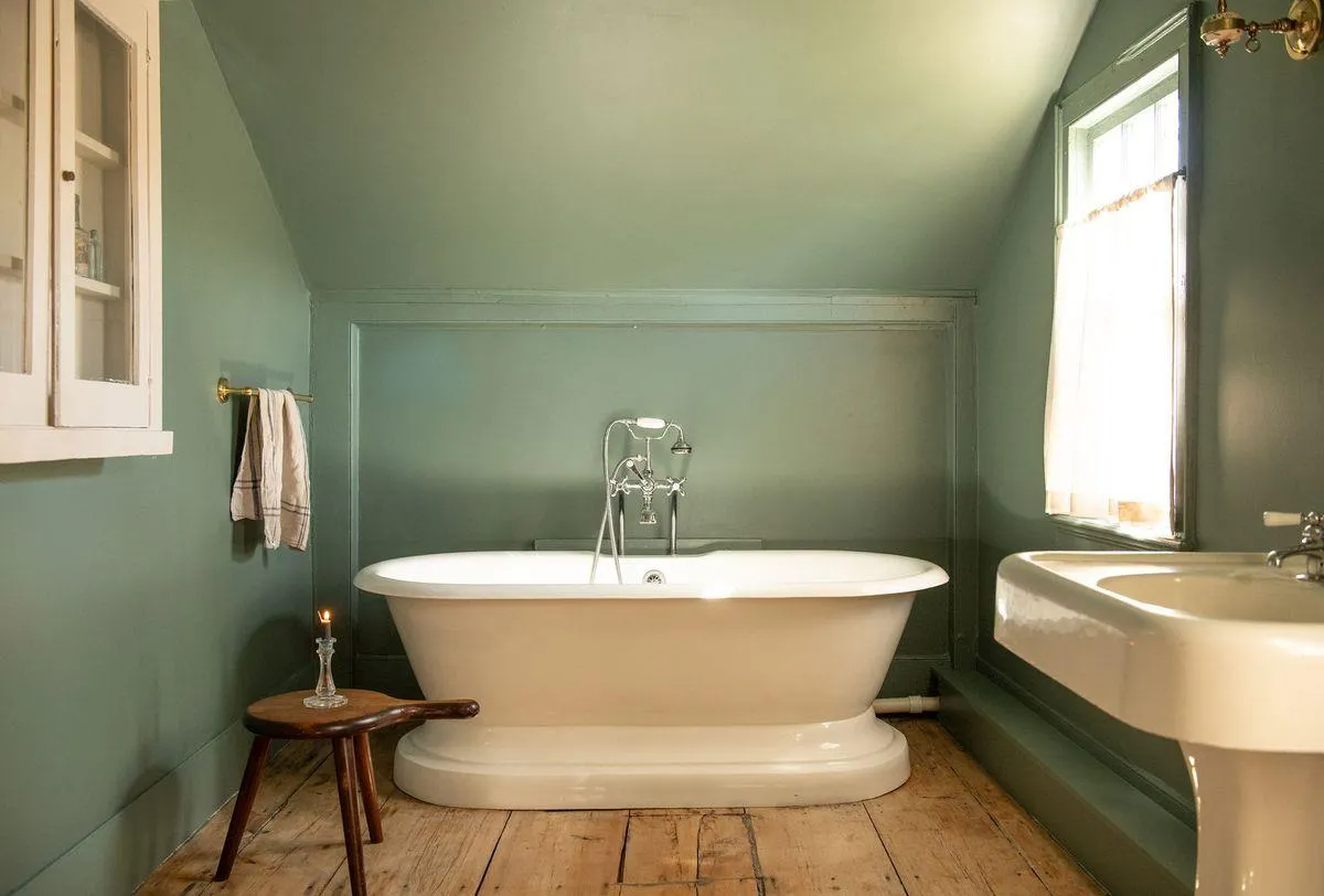 bathroom with pedestal tub, green walls