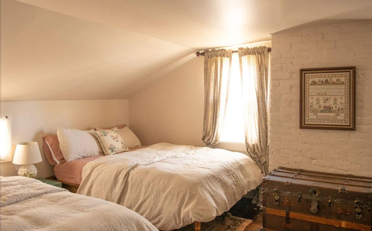 bedroom with exposed brick chimney wall painted white