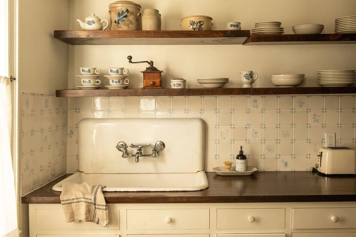 kitchen with wood countertop, floating wood shelves, blue and white backsplash tile