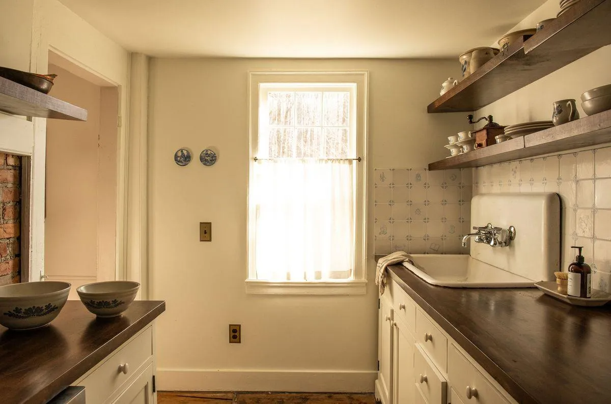 kitchen with cream cabinets, white and blue tile backsplash