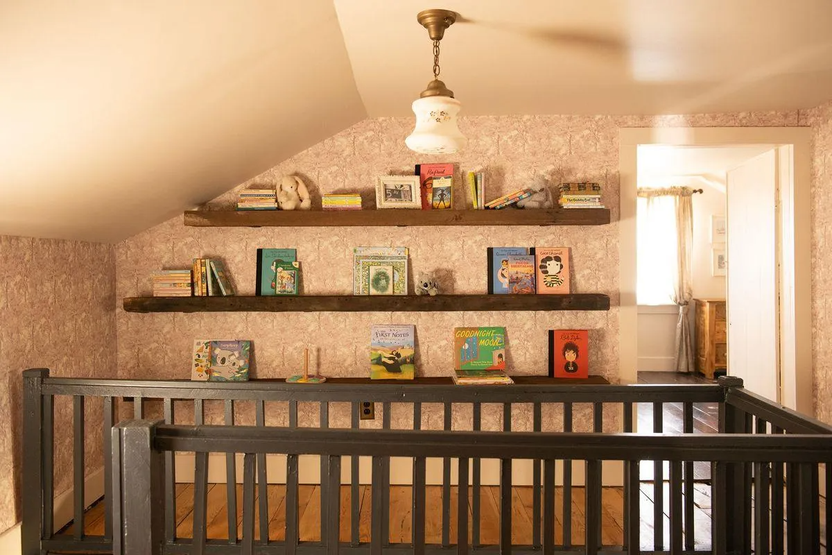 upstairs landing with mauve wallpaper, shelves for books