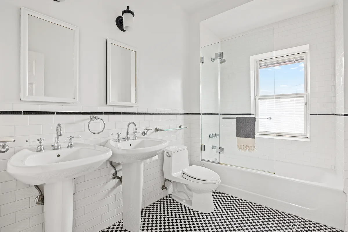 bathroom with white fixtures and a black and white checkerboard floor