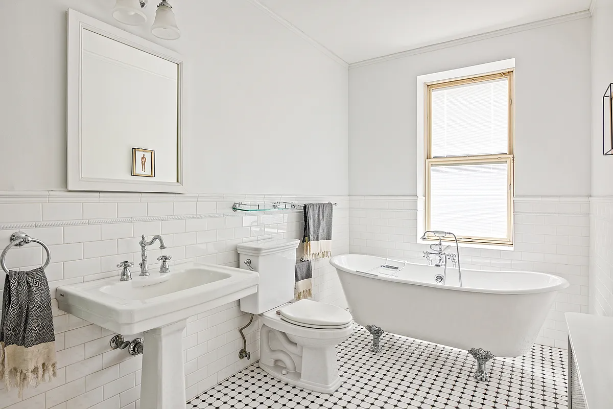 bathroom with white fixtures inlcuding a claw foot tub