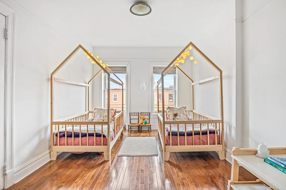 bedroom with white walls, wood floor