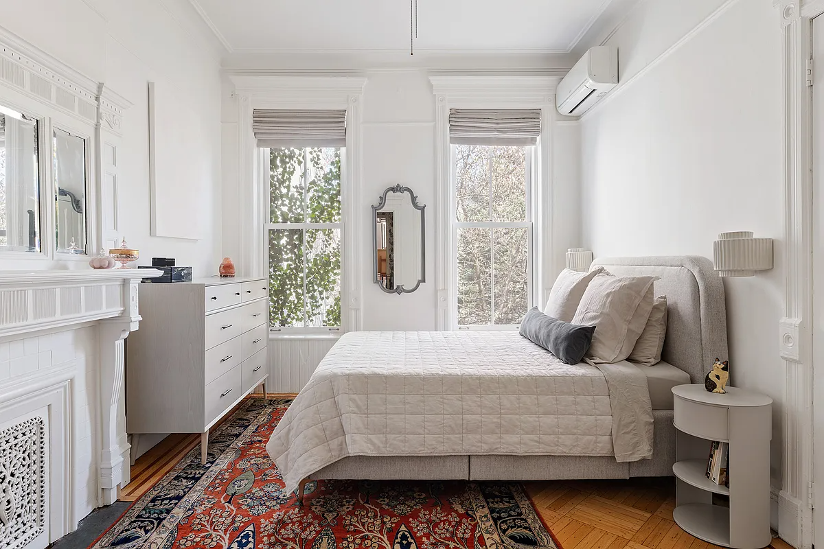 bedroom with white walls and a mantel painted white