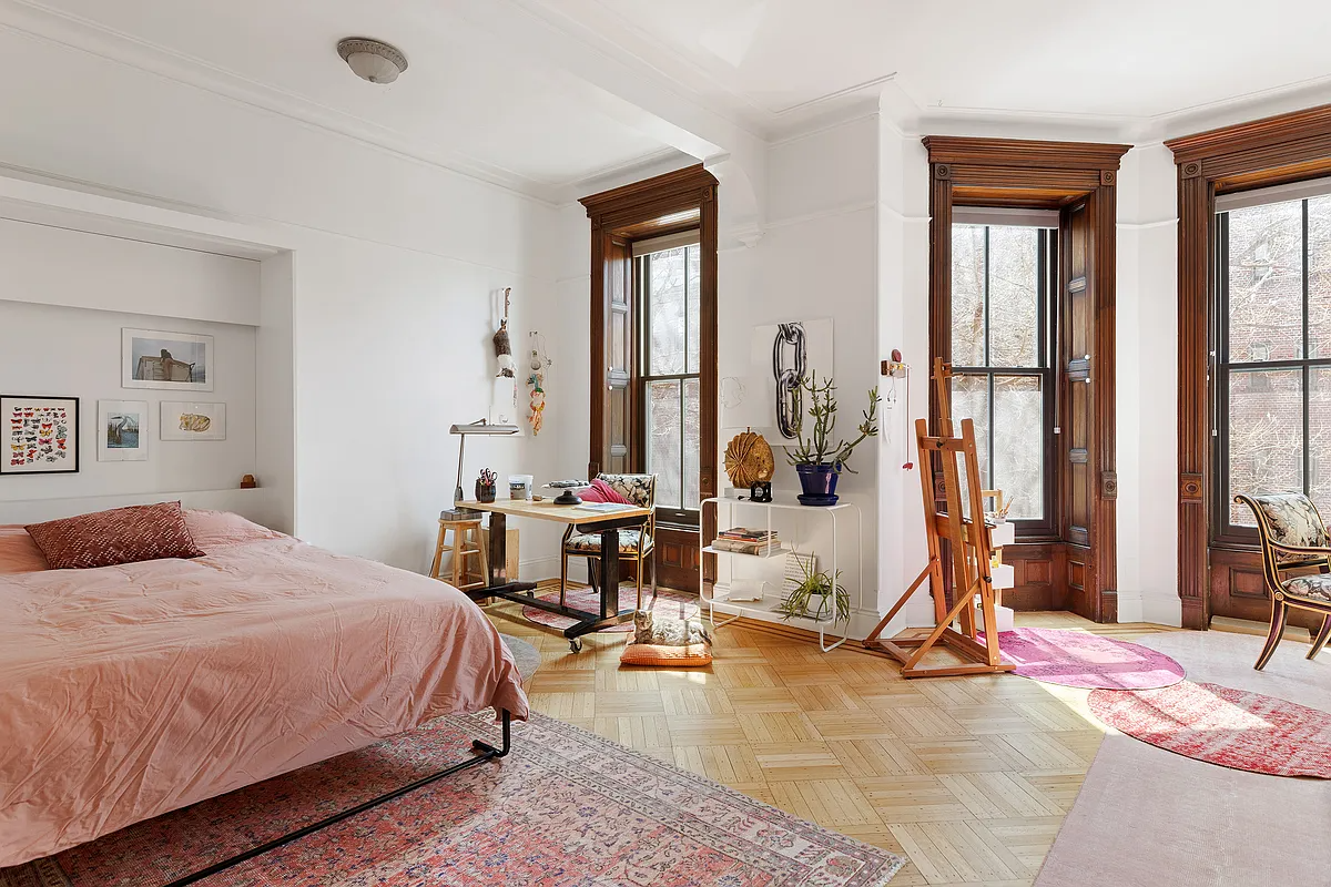bedroom with wood floor, white walls, tall windows