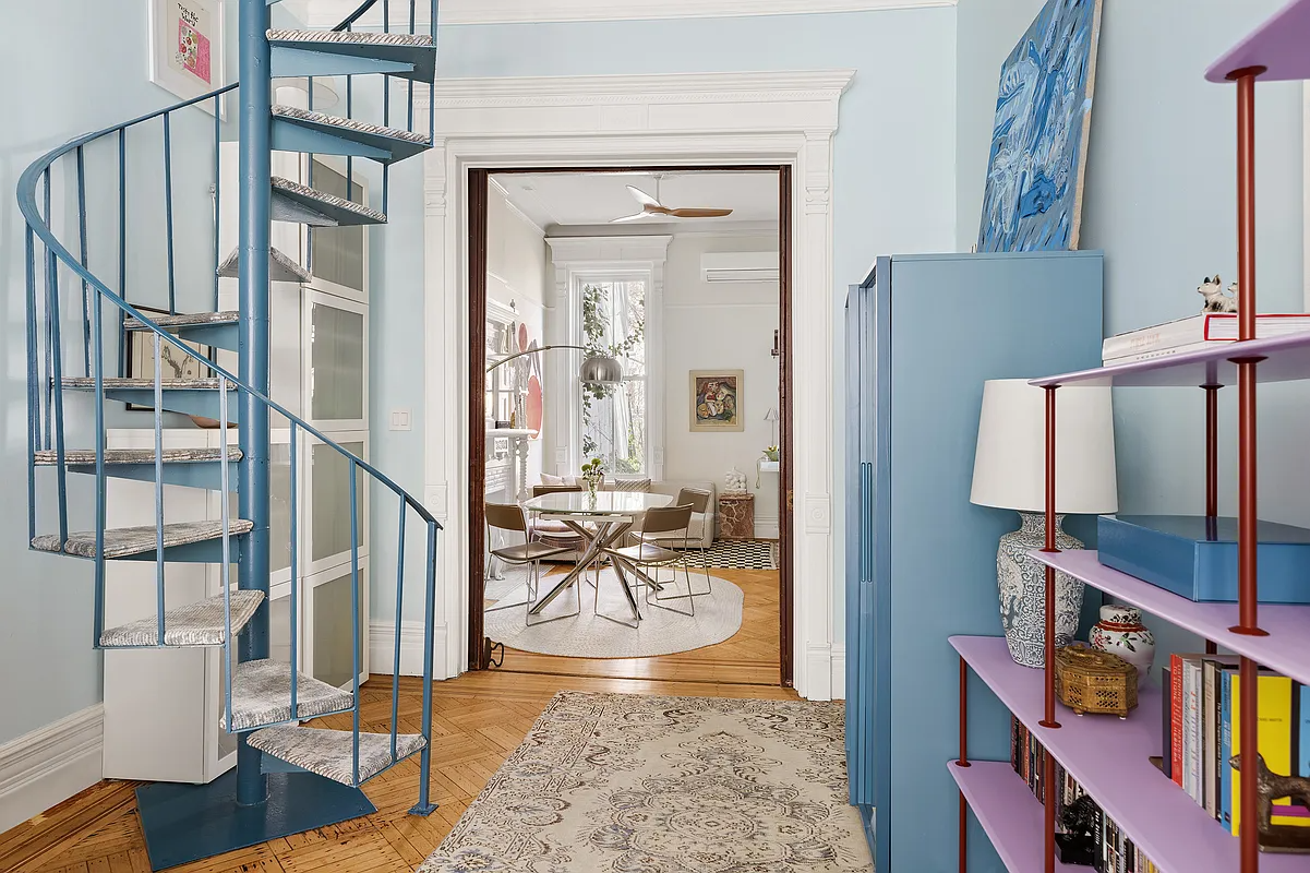 blue, spiral staircase between living room and dining room