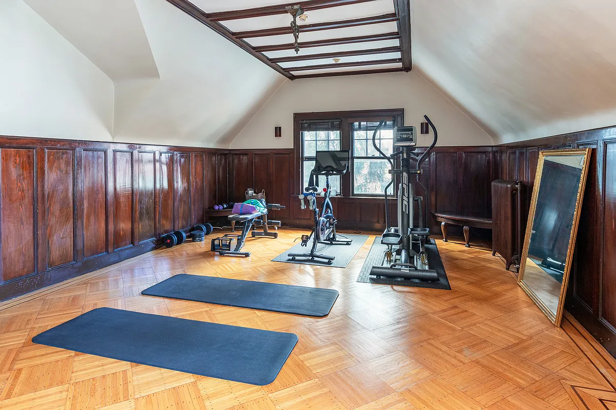 top floor room with wainscoting set up as a gym
