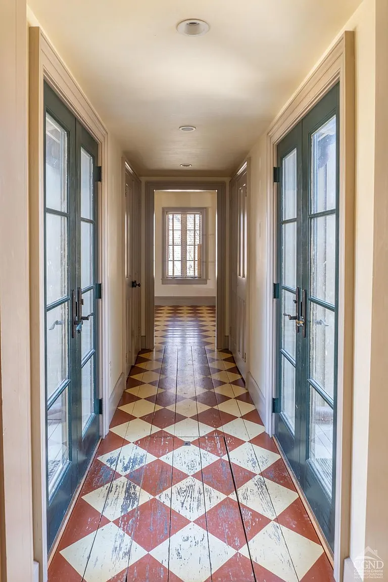 hall to addition with a checkerboard painted wood floor in red and cream
