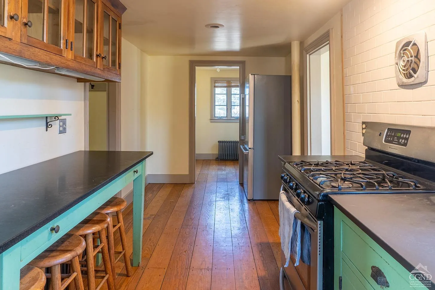 kitchen with white subway tile on one wall and bright green lower cabinets