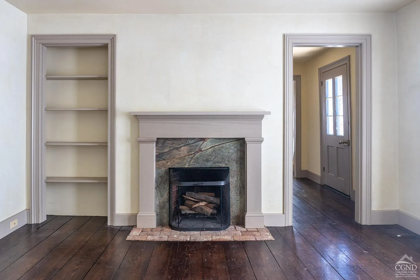 parlor with plain wood mantel, modern stone surround