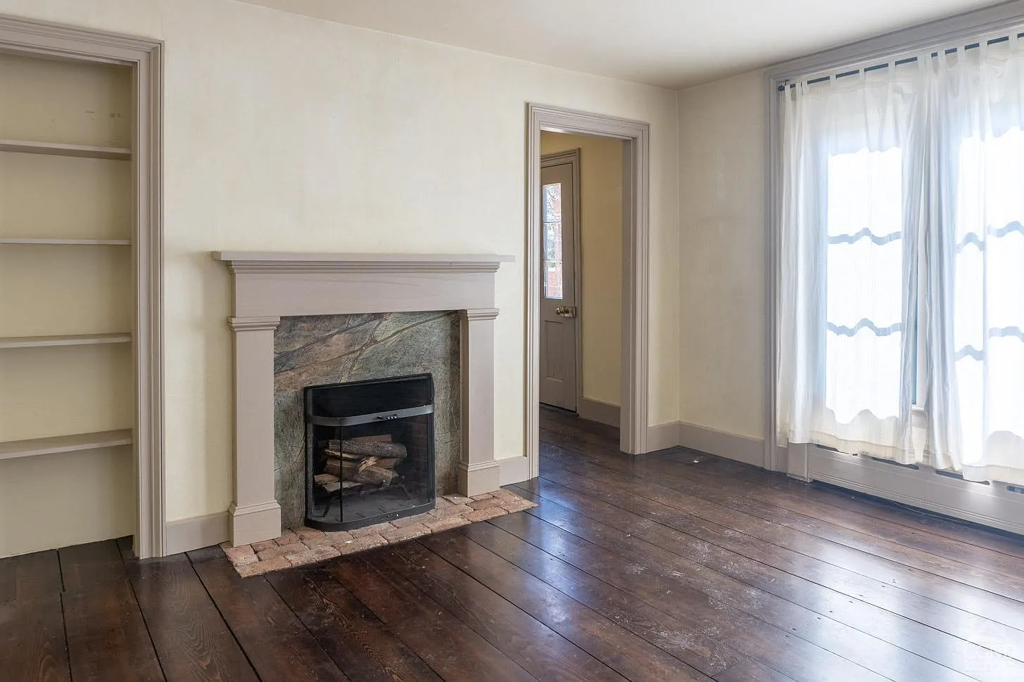 parlor with plain wood mantel, modern stone surround