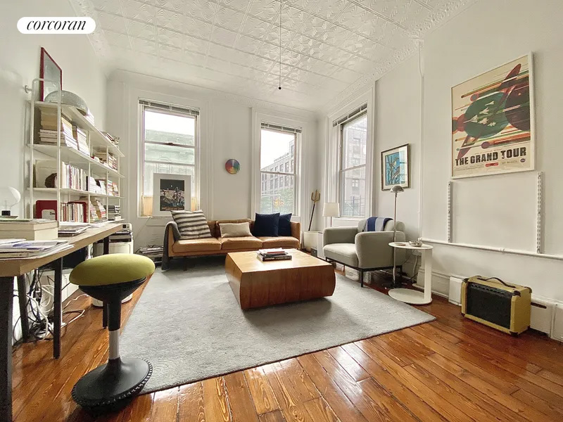 living room with two exposures, wood floor, tin ceiling