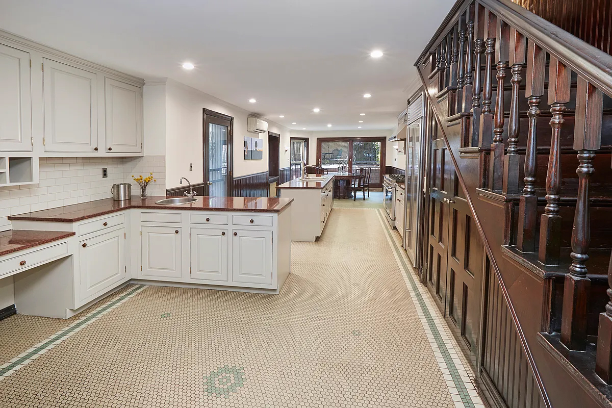 garden level kitchen with tile floor, white cabinets