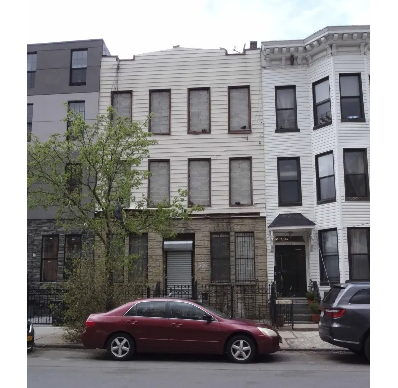 building with permastone at streetlevel and siding above