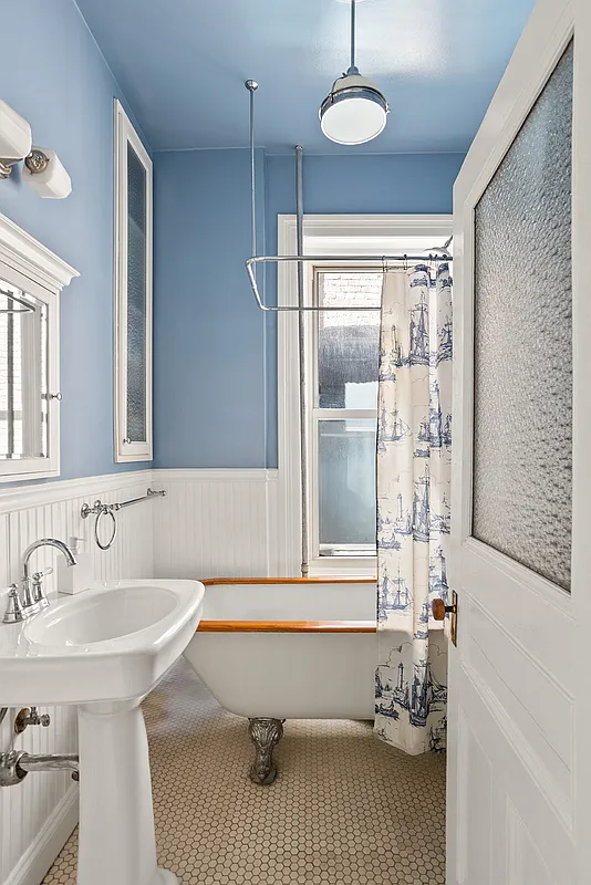 bathroom with beadboard, claw foot tub