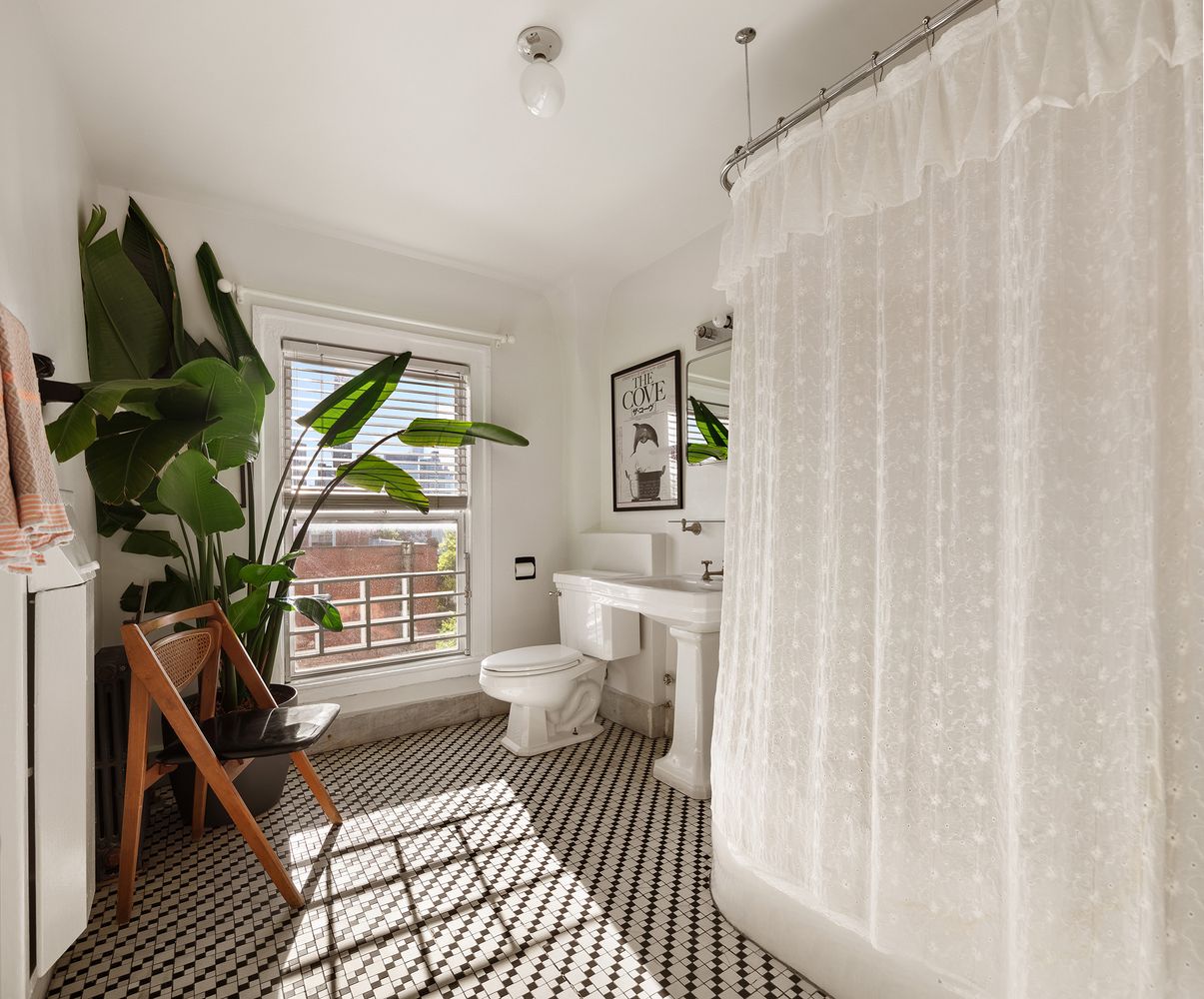 bathroom with white fixtures, black and white floor