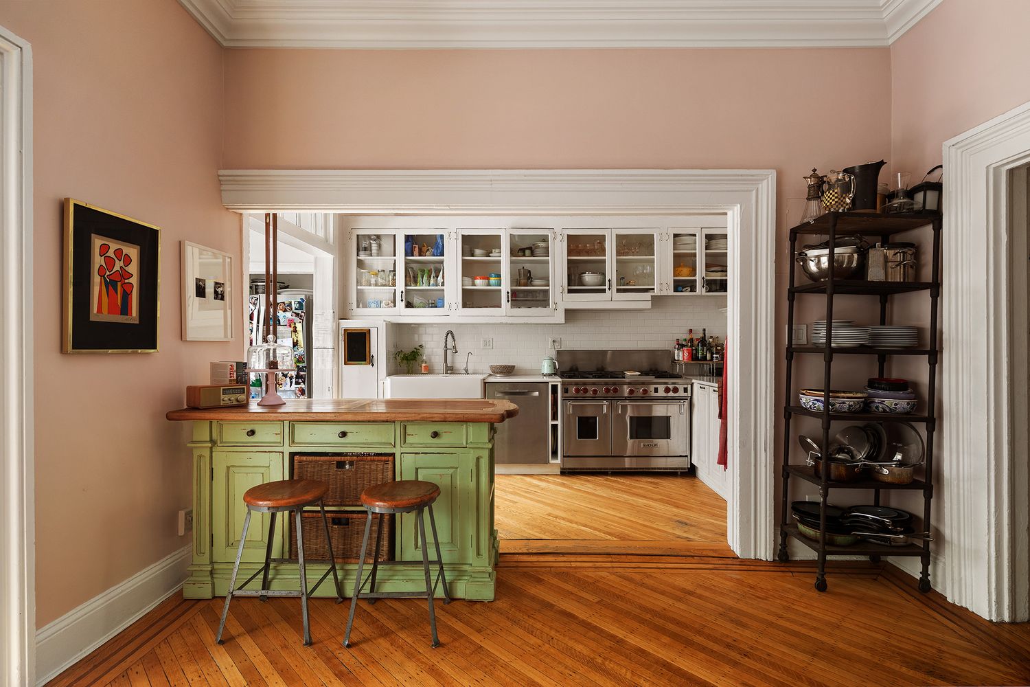 kitchen with white cabinets, apron front sink and a wood green cabinet as an island
