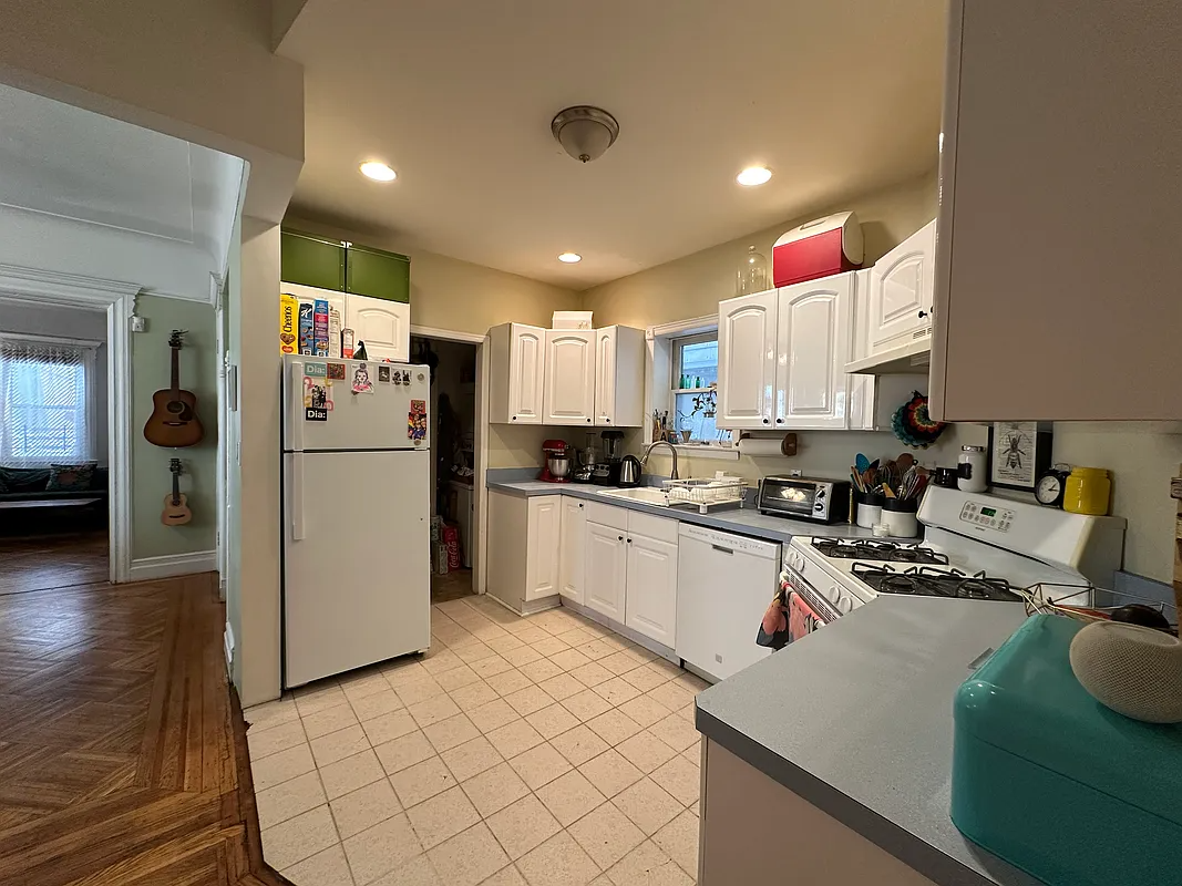 kitchen with tile floor, white cabinets