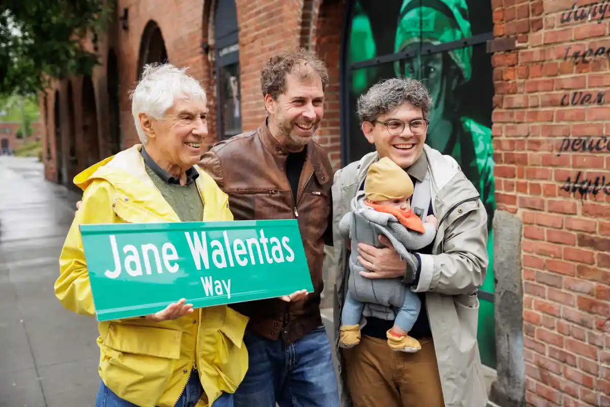 Left to right: David Walentas, Jed Walentas and City Council Member Lincoln Restler pose for a photo with the street sign for ‘Jane Walentas Way’ on the corner of Old Dock Street and Water Street in Dumbo on Tuesday, May 6, 2025.