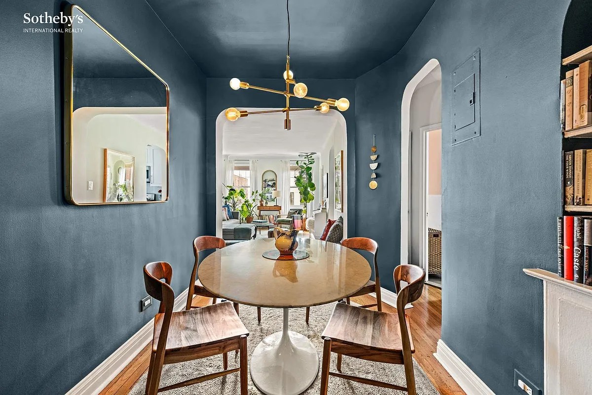 foyer with dark blue walls staged as a dining room