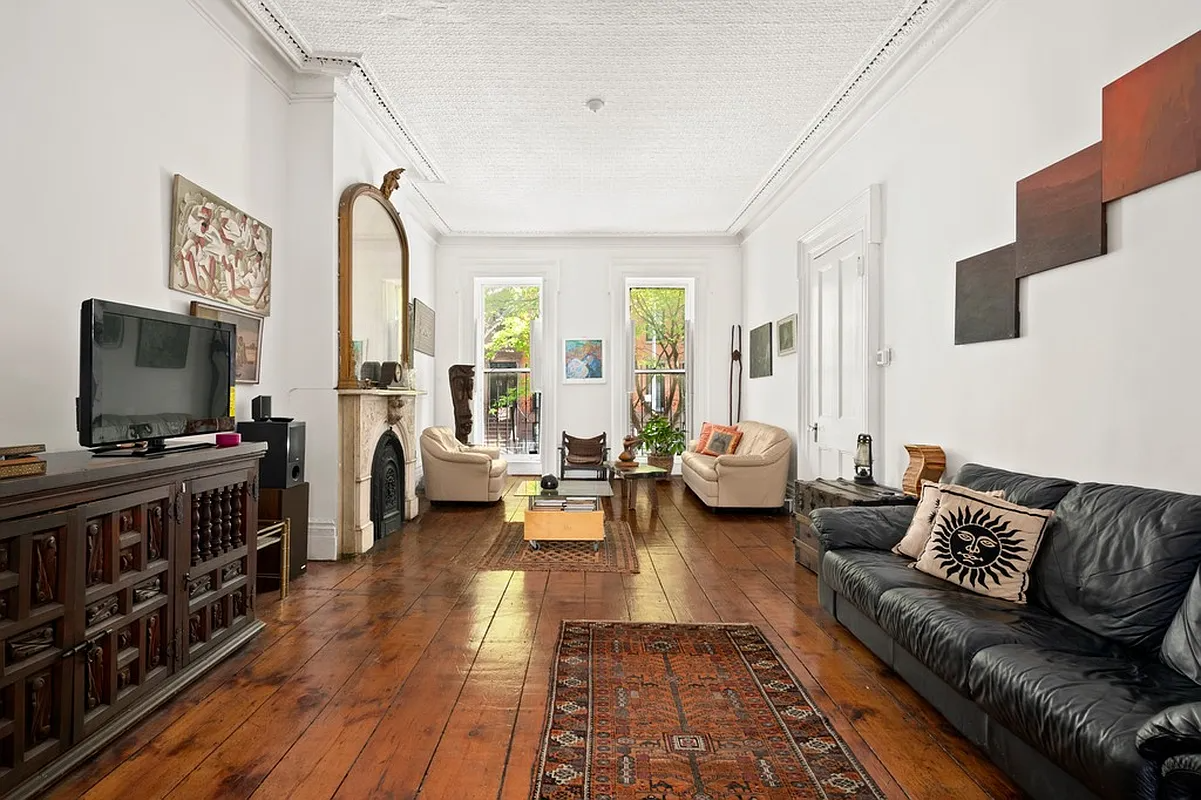 parlor with wide plank floorboards and a marble mantel