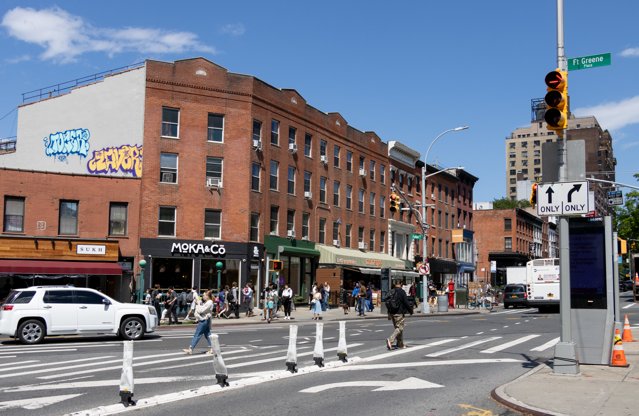 brooklyn - pedestrians crossing fulton street with businesses and restaurants in the background