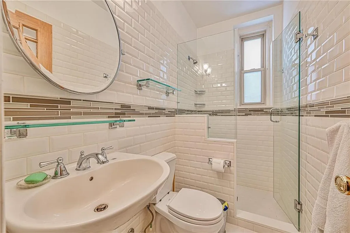 bathroom with white tiles and a shower