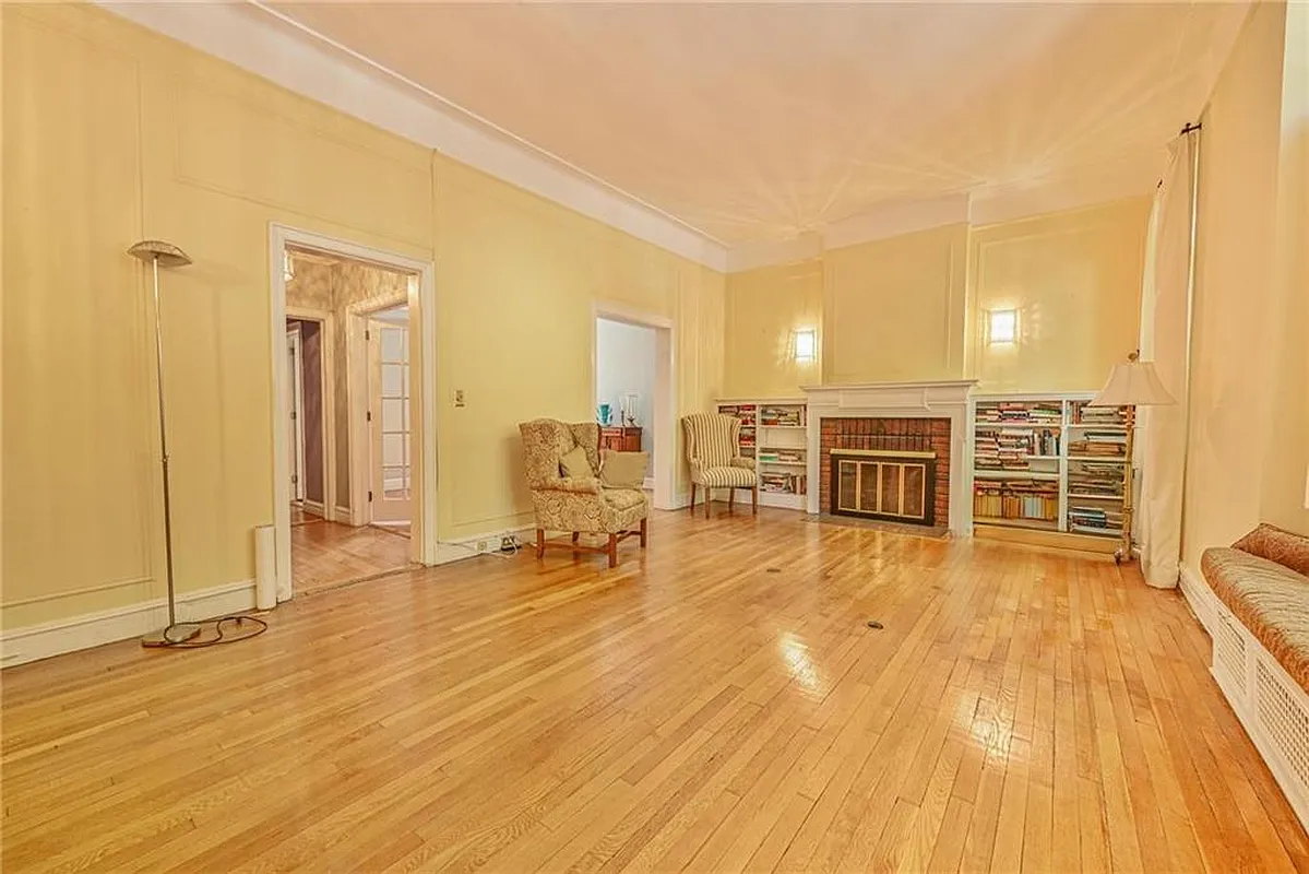 living room with yellow walls, mantel, built-in bookshelves