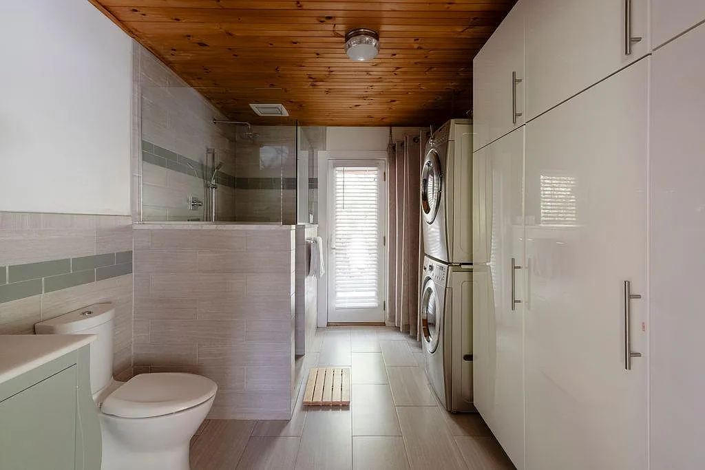 bathroom with walk-in shower and stacked laundry