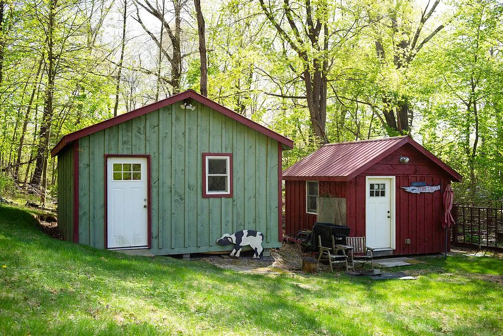 two outbuildings, one painted green and one red
