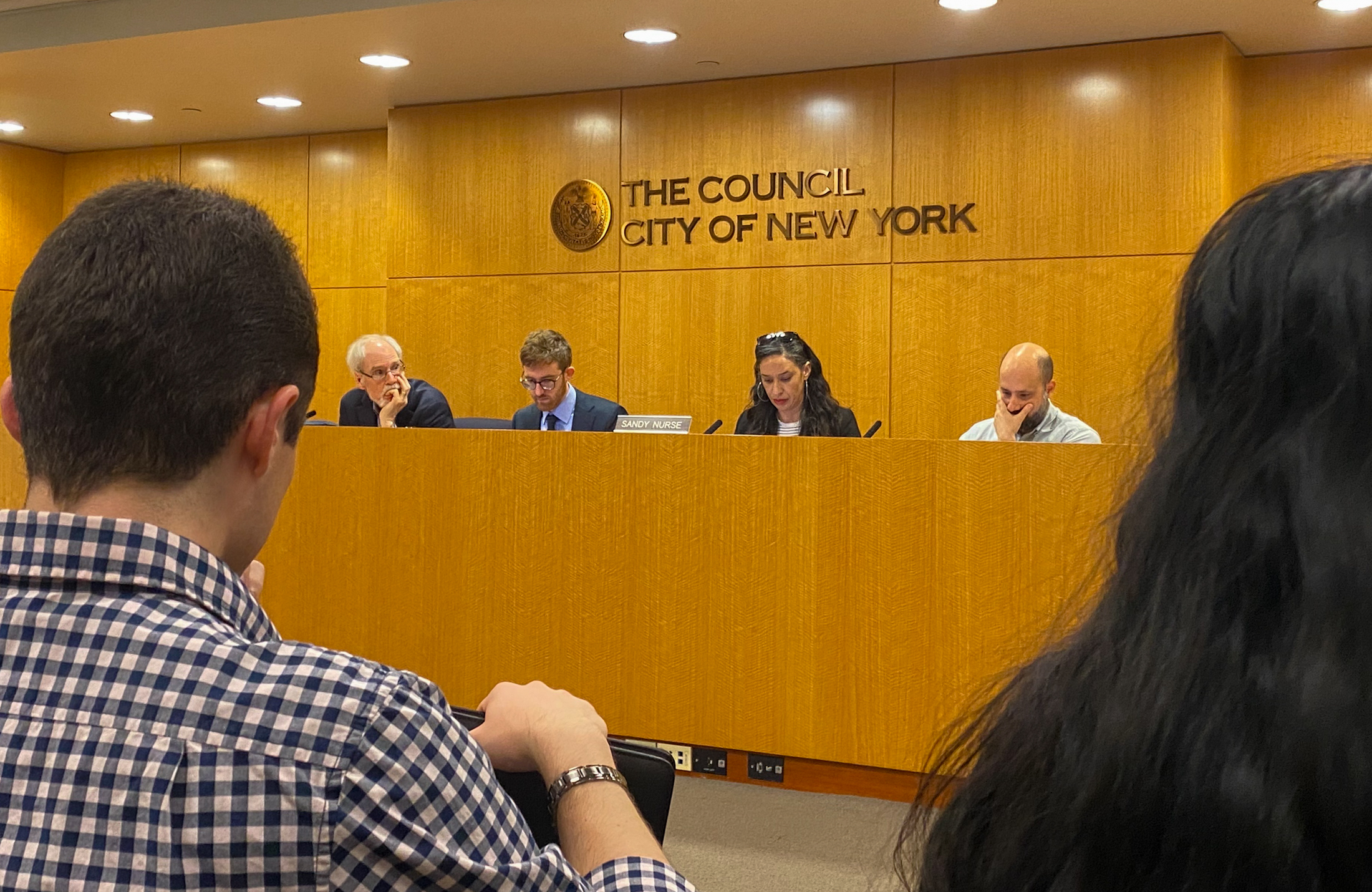 tax lien sale - people looking at speakers in a meeting room for the city council