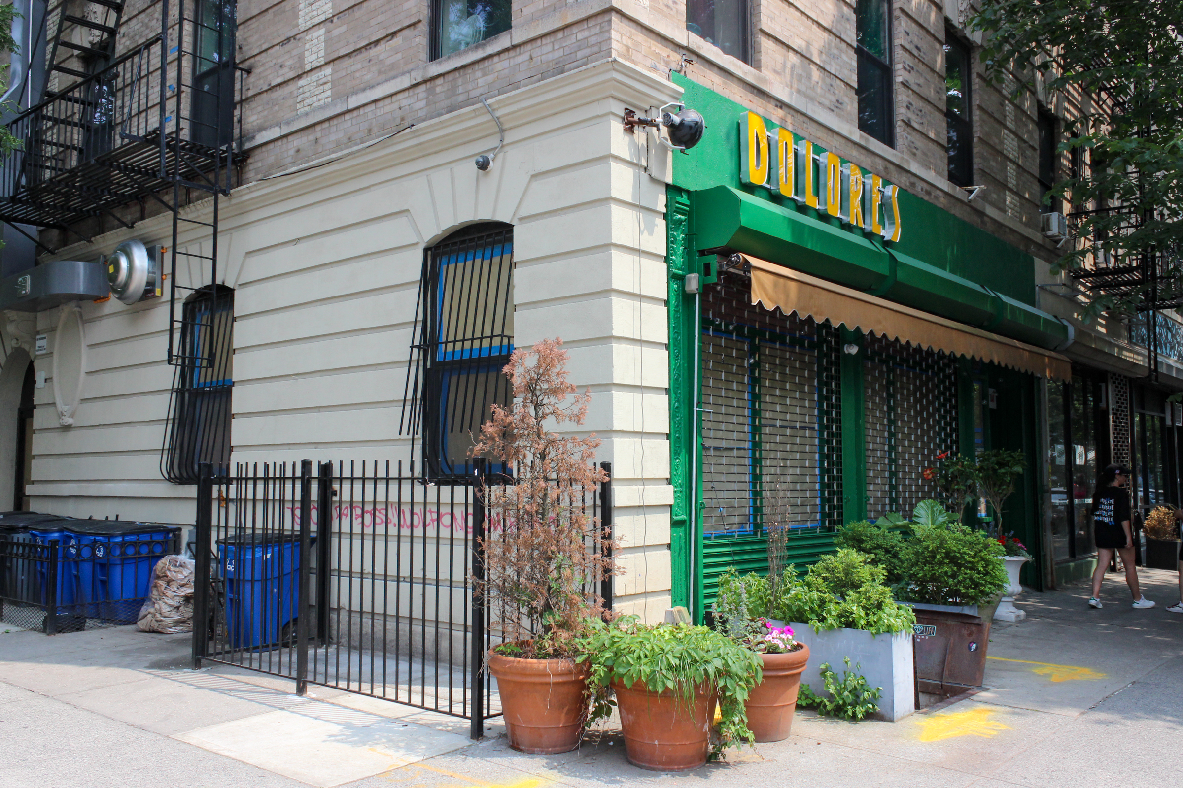 a bright green storefront with dolores sign in yellow