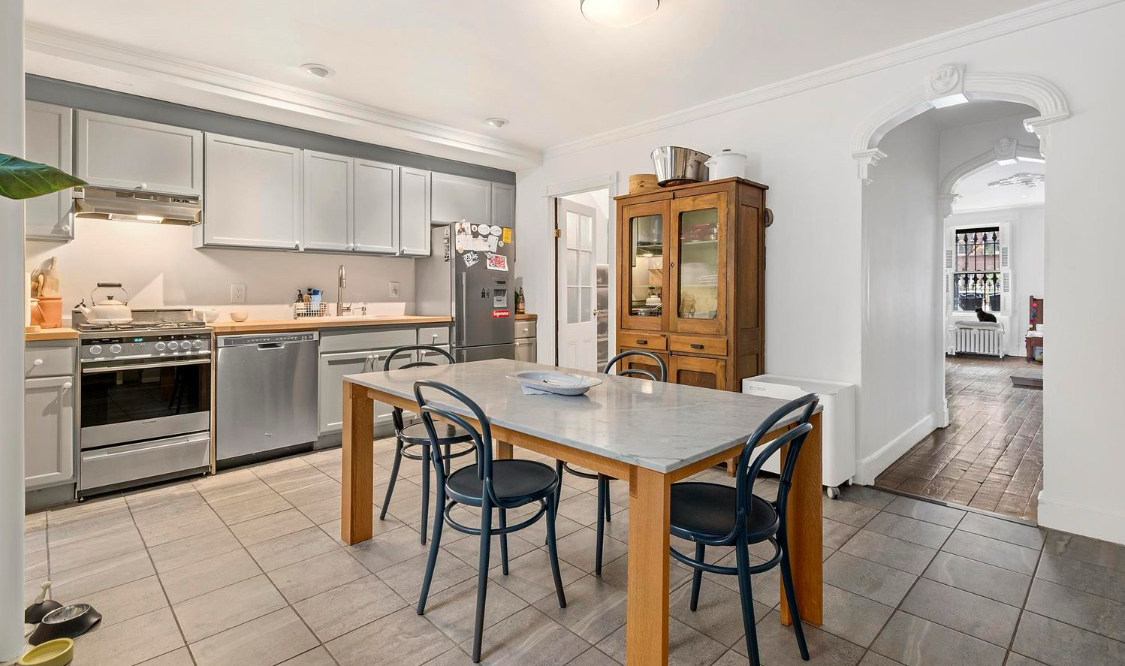 kitchen with gray floor and cabinets and room for dining