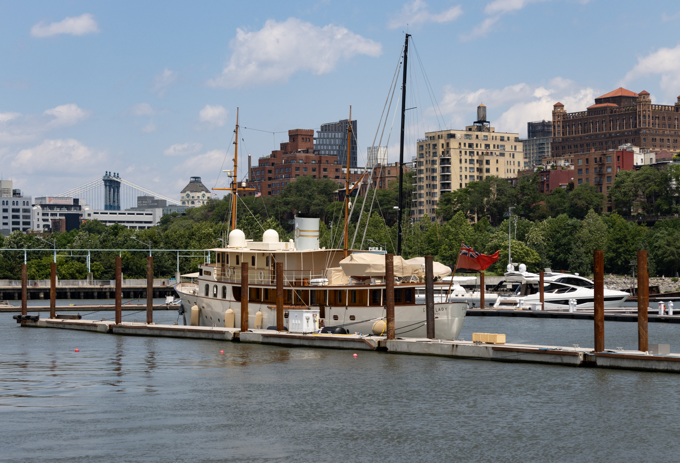 view of the boats in the brooklyn bridge marina with the brooklyn heights skyline in the distance