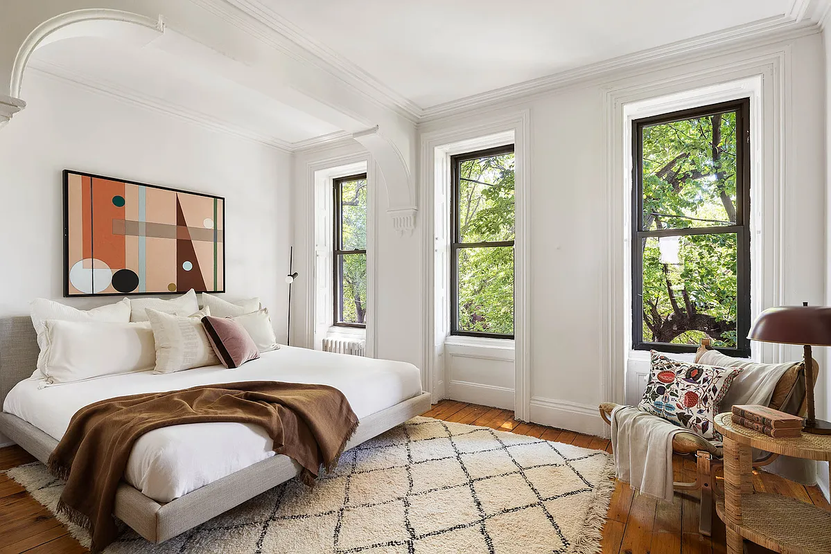 bedroom with nook, white walls, wood floor