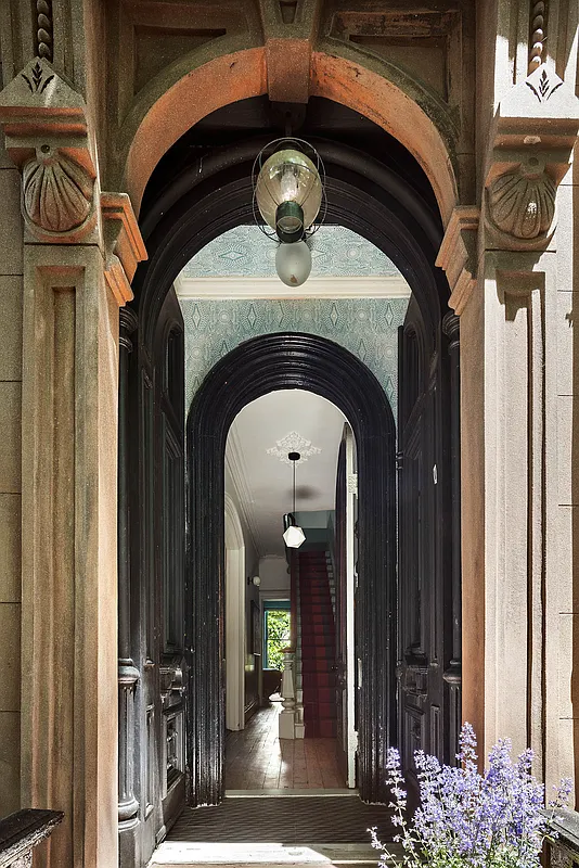 vestibule with view into wood floor of entry and stair with runner
