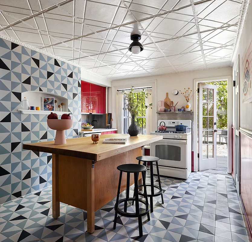 kitchen with checkerboard tile on floor and up a wall, tin ceiling, and a door to the garden