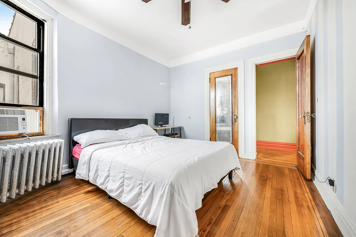 bedroom with blue walls, wood floor, ceiling fan