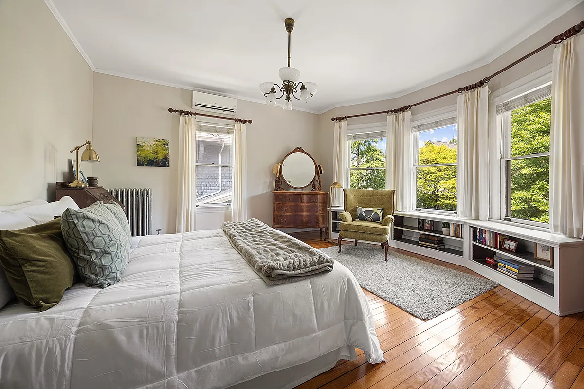 bedroom with built-in bookshelves under the bay window