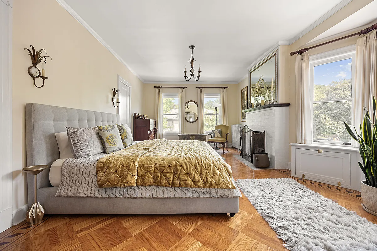 bedroom with two exposures, a mantel, wood floor