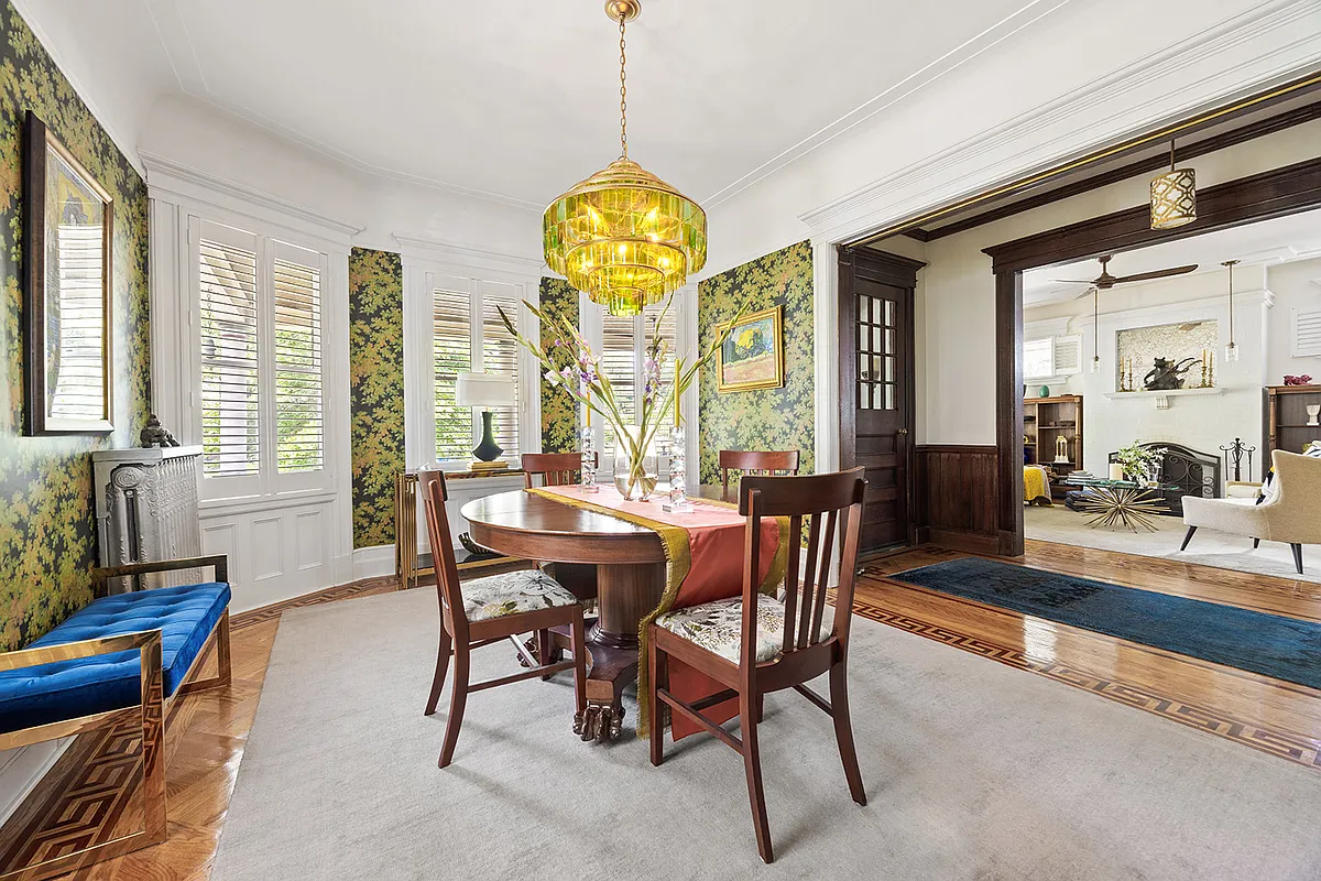 dining room with bold, tree wallpaper and a view to foyer and parlor beyond