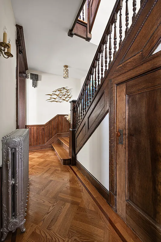 stair hall on first floor with wainscoting, wood floor
