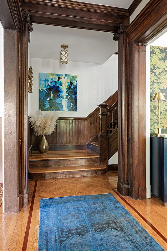 view from entry to stair with wood pilasters in doorways