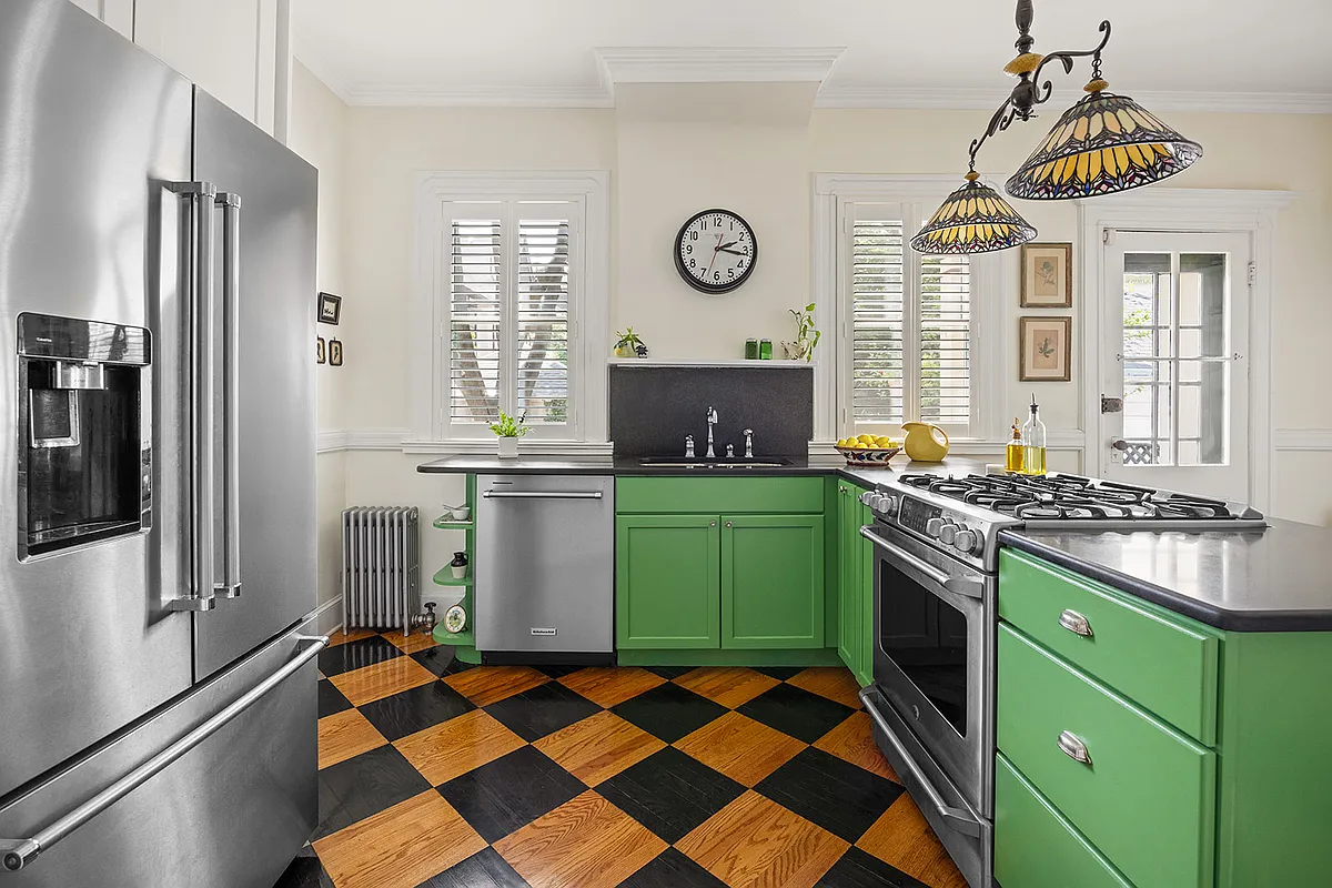 kitchen with spring green cabinets, wood floor painted with black checkerboard