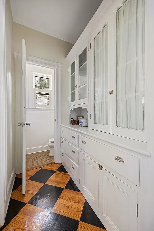 original built-in cabinet in kitchen and a view of the half bath