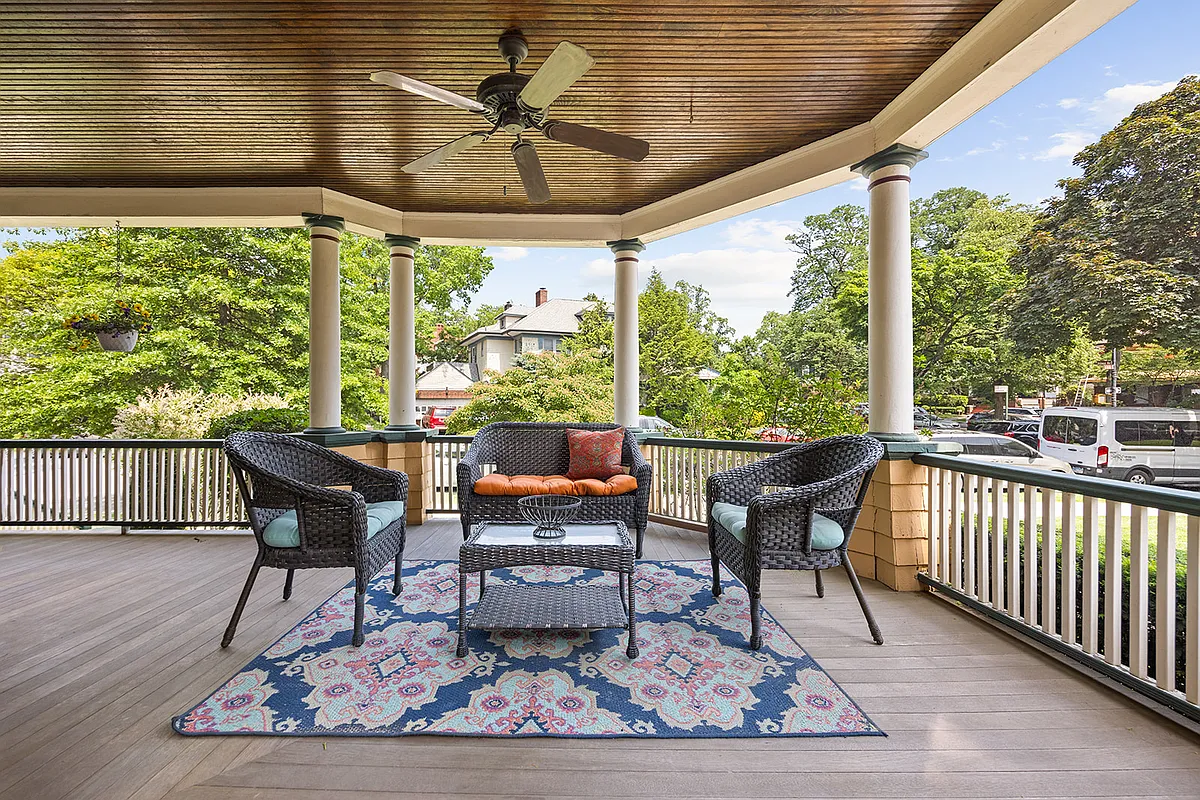 warparound porch with a ceiling fan and room for dining
