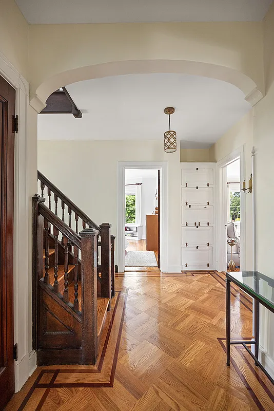 second floor hallway with wood floor, built-in storage and a stair to the upstairs