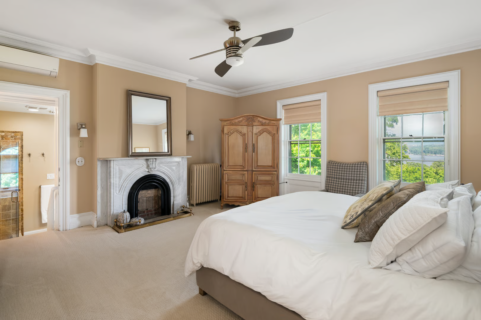 bedroom with wall-to-wall carpet, ceiling fan, marble mantel
