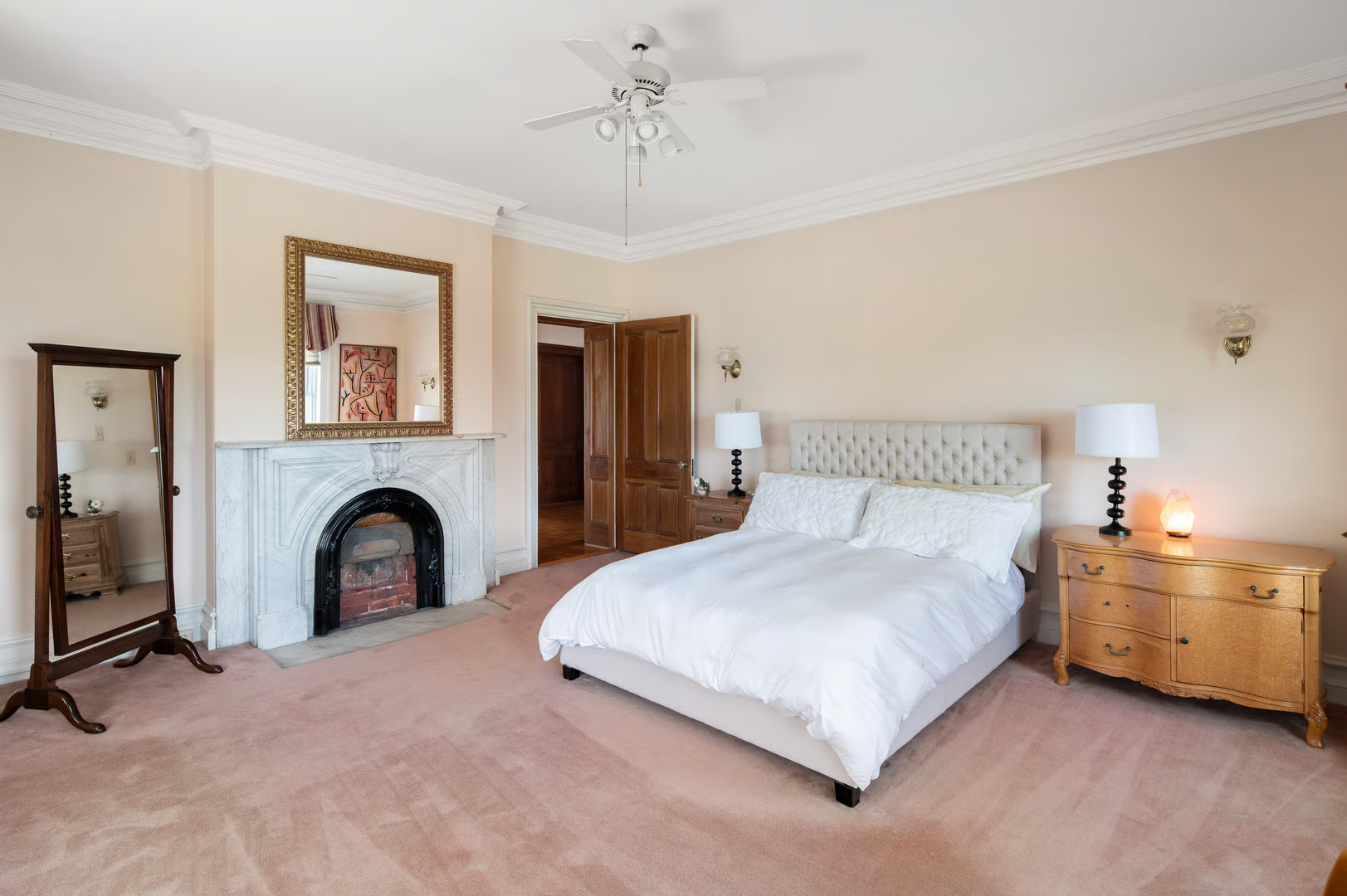 bedroom with wall-to-wall carpet, ceiling fan, marble mantel